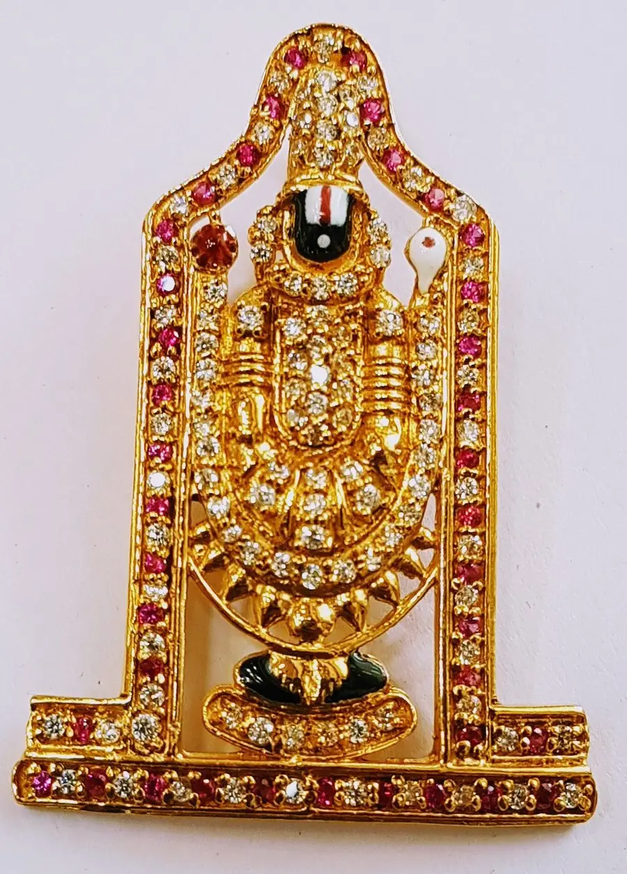 A gold Venkateswara plaque set with red and white stones.